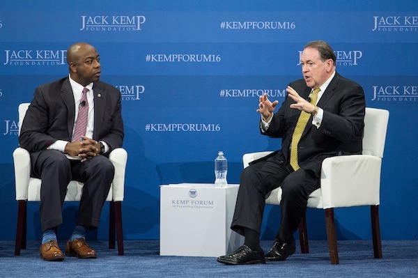 Republican presidential candidate Mike Huckabee, right speaks with Sen. Tim Scott, R-S.C., left, at an economic forum, Saturday, Jan. 9, 2016, in Columbia, S.C. Huckabee pitched his “fair tax,” a single-rate consumption tax to replace all other taxes on wages, investments on inheritance. “It’s a powerful unlocking of the economy,” Huckabee said, noting that he would allow something similar to the Earned Income Tax Credit to ease the tax burden on low-income households. (AP Photo/Sean Rayford)