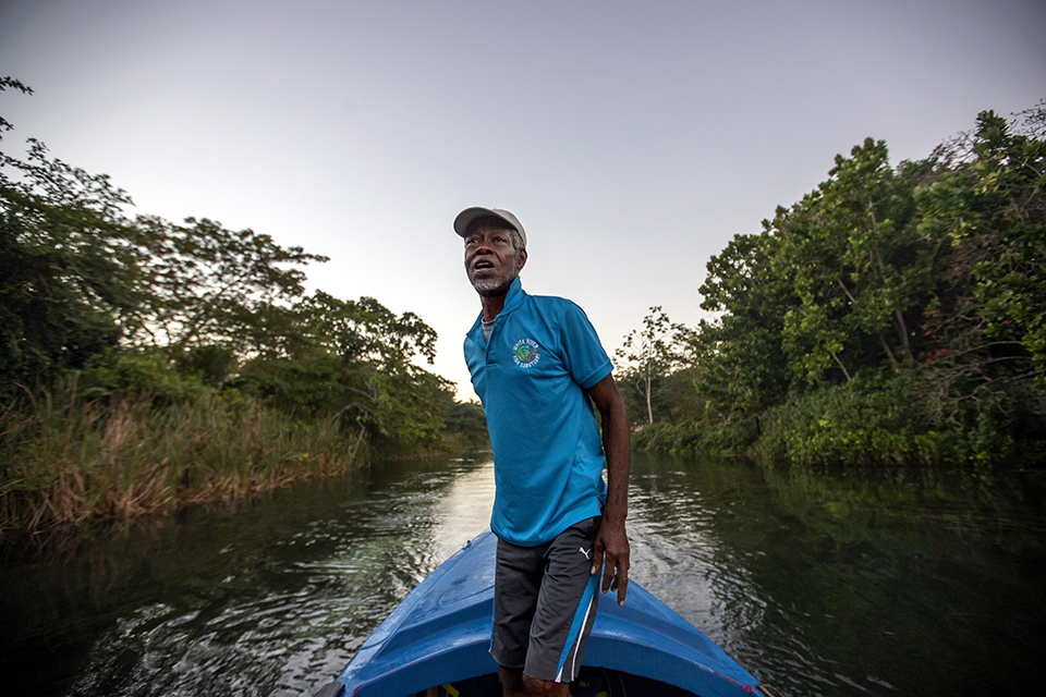 White River Fish Sanctuary warden and diver Everton Simpson heads out to sea to patrol against illegal fishing at dawn in White River, Jamaica, Tuesday, Feb. 12, 2019. Once a spear fisherman and later a scuba-diving instructor, Simpson started working as a "coral gardener" and warden two years ago, part of grassroots efforts to bring Jamaica's coral reefs back from the brink. (AP Photo/David Goldman)